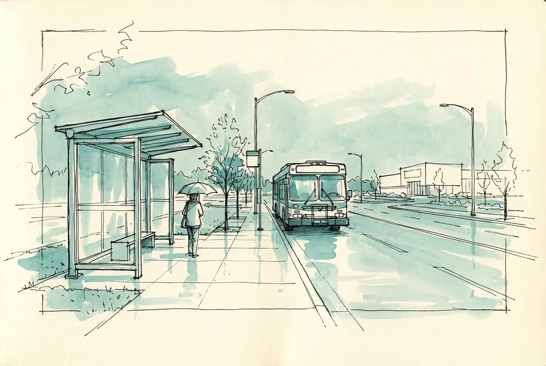 Bus shelter on a wide boulevard in drizzle